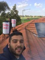 ליאור ואיש צוות מחברת "מקור החום" בעת התקנת דוד שמש על גג