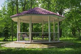 פרגולת נוי בפארק עם קירוי רעפים ביום שמש