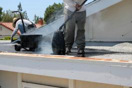 קבלני איטום משתמשים בזפת חמה במריחה לאיטום גג