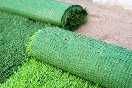 צילום של מרבדי דשא סינטטי המונחים על מצע חול