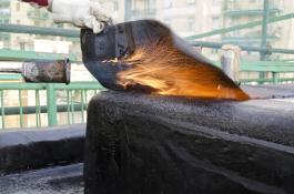 חימום יריעות ביטומניות עם להבה כחלק מהכנות לעבודת איטום בנתיבות