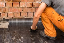 צילום של קבלן איטום מקצועי בהנחת יריעות איטום צמוד לקיר גג בנס ציונה